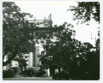 Photographie de la façade nord (entrée principale) de la villa de Riond-Bosson cachée par les arbres