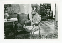 Photographie du coin du salon de Riond-Bosson, avec au fond le cabinet des trophées avec sa table de bridge