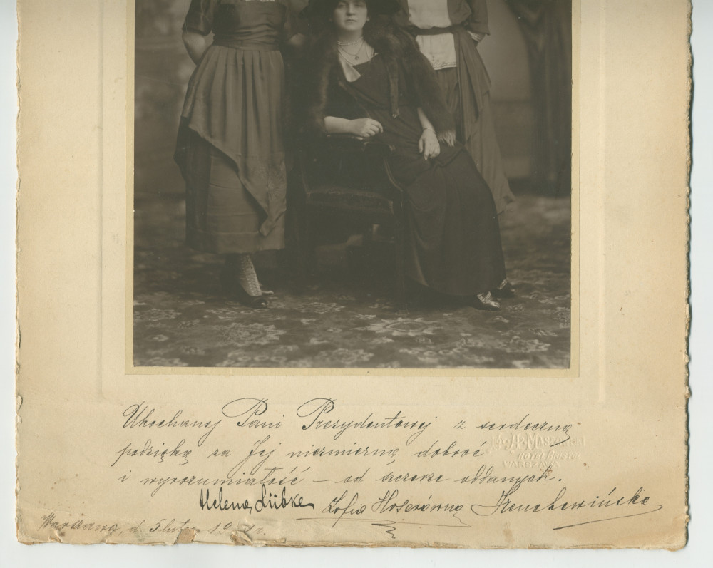 Photographie d'Hélène Paderewska, avec chapeau noir et collier de perles, assise entourée de trois jeunes femmes dont sa secrétaire Mlle Hélène Lübke (debout au milieu), réalisée probablement le 5 février 1920