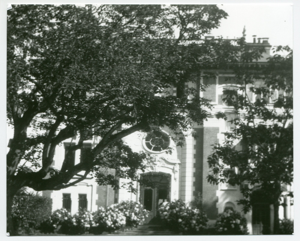 Photographie de la façade nord (entrée principale) de la villa de Riond-Bosson cachée par le catalpa (arbre «trompette»)