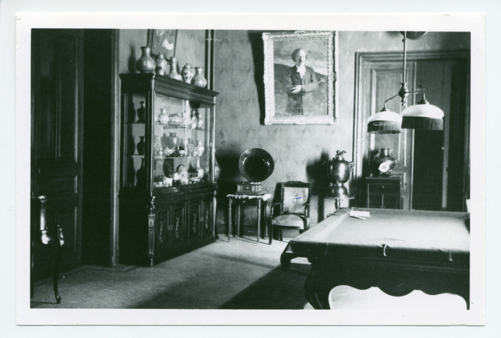 Photographie du hall de Riond-Bosson avec une vitrine, un gramophone, le billard et le portrait d'Ignace Paderewski par Charles Giron