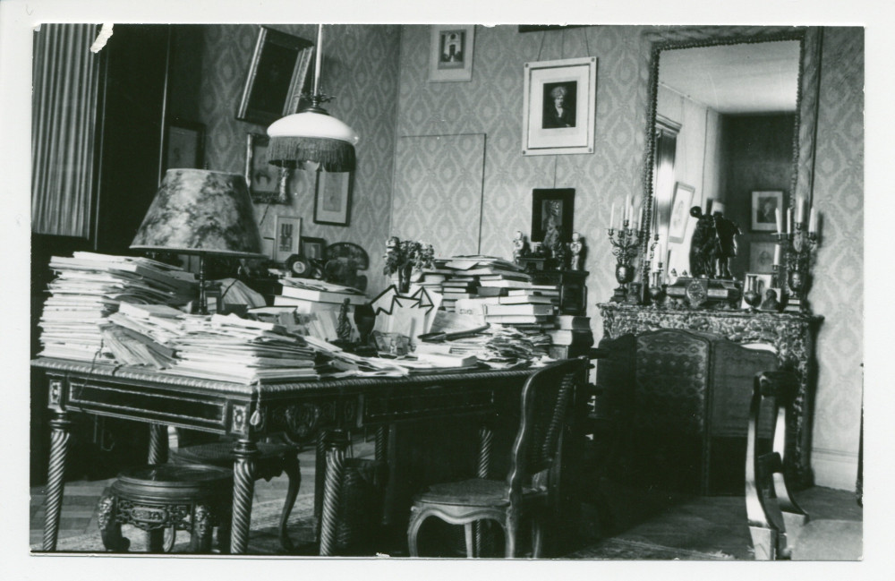 Photographie du studio de Paderewski à Riond-Bosson depuis le piano droit, avec son bureau recouvert de documents