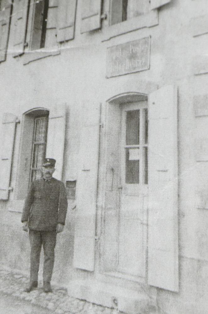 Photographie du buraliste postal de Tolochenaz, Emile Panchaud, devant le bureau de poste du 17 de la rue du Centre, en 1900
