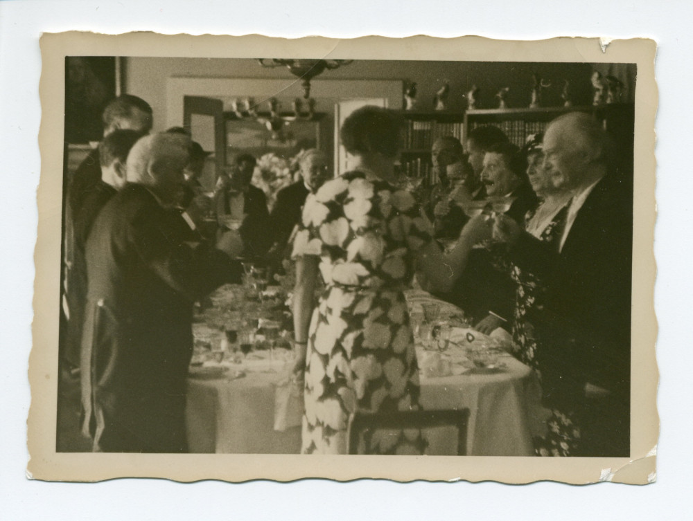 Photographie de Paderewski portant un toast lors de la réception organisée chez lui à Saint-Sulpice par le conseiller national Henry Vallotton (en bout de table), le 8 juillet 1933, après la remise de la bourgeoisie d'honneur de la Ville de Lausanne