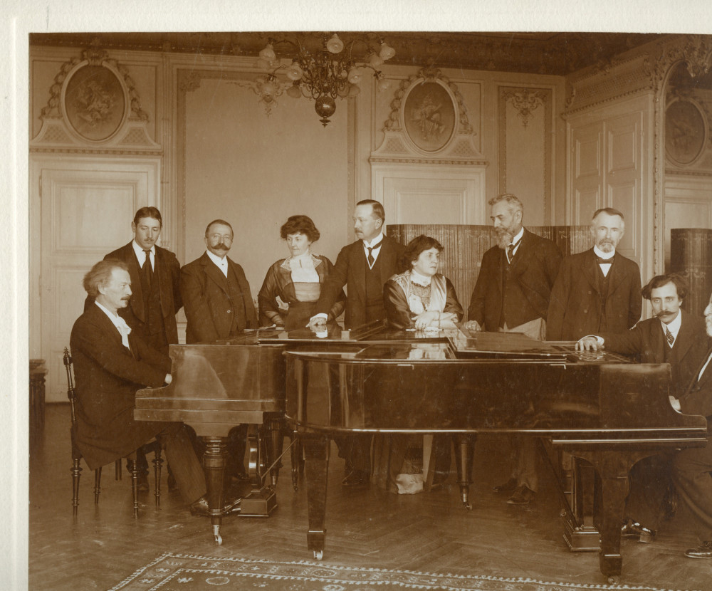 Photographie signée de Francis de Jongh représentant Paderewski et Camille Saint-Saëns face-à-face au piano dans les salons de l'Hôtel des Trois Couronnes à Vevey dans le cadre des Fêtes musicales données en mai 1913 en l'honneur de Camille Saint-Saëns