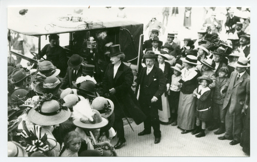 Photographie de Paderewski sortant de sa voiture au milieu de la foule à Vevey, se rendant aux Fêtes musicales données du 18 au 21 mai 1913 au Casino du Rivage en l'honneur de Camille Saint-Saëns