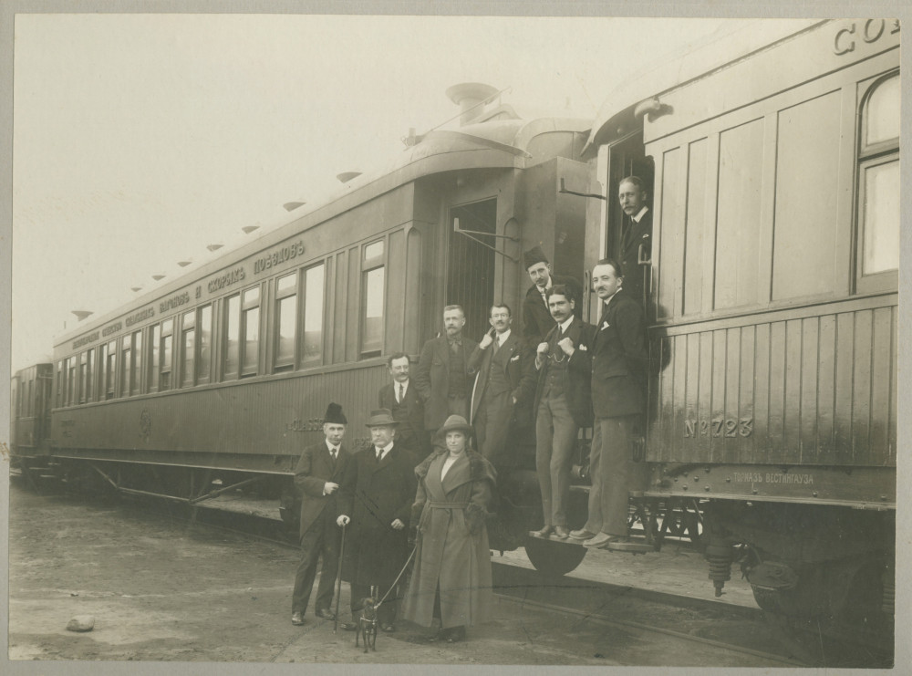 Photographie du ministre français de l'Agriculture et du Ravitaillement Joseph Noulens au pied d'un train avec différentes personnes (collaborateurs?) – avec dédicace manuscrite datée du 1er mai 1919 à Paris «à Madame Paderewska…»