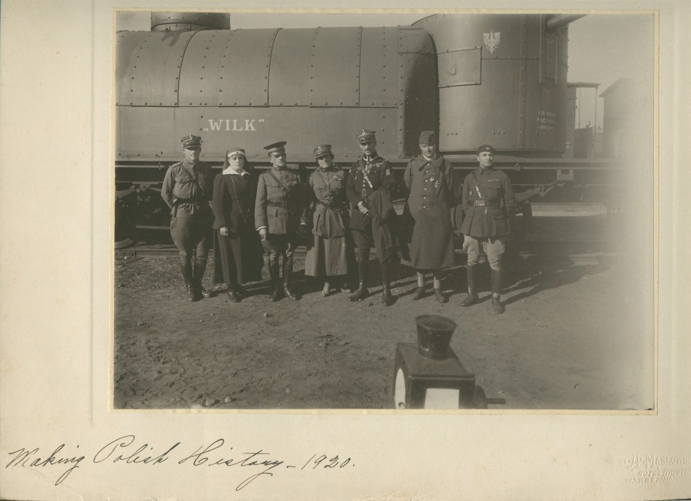 Photographie de militaires et d'une infirmière devant un wagon (avec canon?) baptisé «Wilk» – légende manuscrite: «Making Polish History – 1920» [«Faire l'histoire de la Pologne – 1920»]