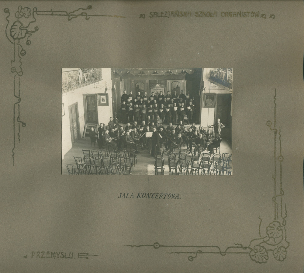 Album de présentation de l'Oratoire (école) salésien pour organistes de Przemysl, réalisé à l'occasion de l'année scolaire 1922-1923 – page 15: photographie de la salle de concert avec chœur et orchestre