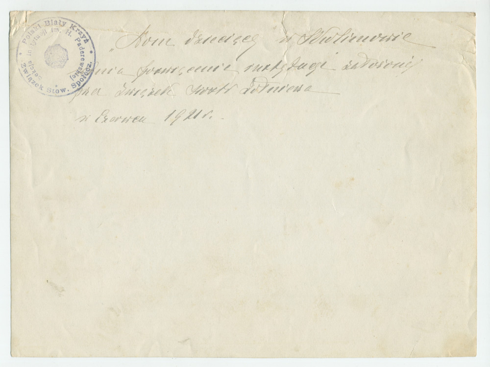 Photographie de groupe devant une école de la Croix Blanche polonaise, avec au centre Mme Rembielinska (fidèle collaboratrice des œuvres de charité d'Hélène Paderewska) et des officiers polonais, en juin 1921