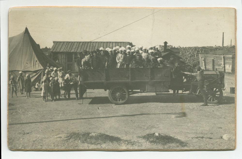 Photographie d'enfants «candidats à l'émigration» sur le pont d'un camion, prêts au départ d'une crèche de la Fondation éducative Hélène Paderewska, probablement en 1922 – avec légende manuscrite et tampons au verso