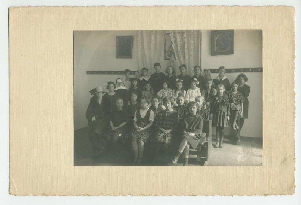 Photographie d'une classe de filles de quatrième année (sans doute financée par la Croix Blanche polonaise) avec enseignants (religieux) – avec signatures de toutes les élèves et tampon du photographe au verso