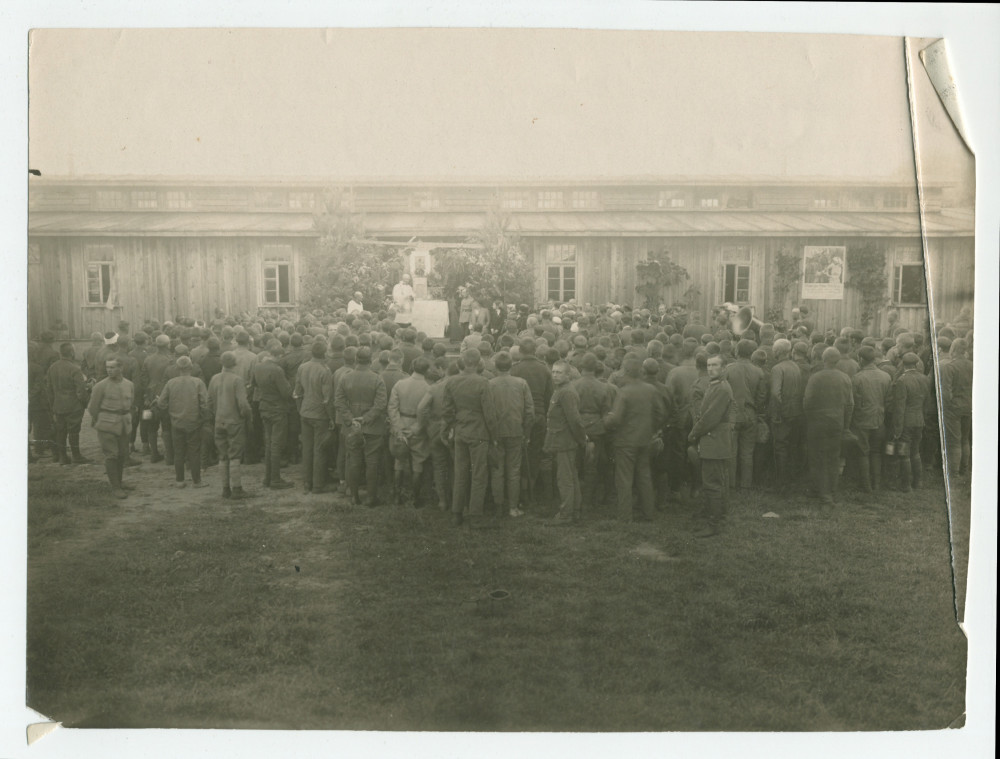 Photographie (de presse) de la «bénédiction de la maison pour les prisonniers de guerre par la Croix Blanche polonaise à Deblin», ville de la voïvodie de Lublin, dans l'est de la Pologne – avec légende manuscrite et tampon «service de presse» au verso
