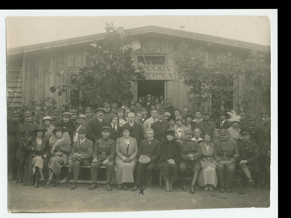 Photographie (de presse) d'un groupe de militaires (dont sans doute un officier français au premier rang), d'hommes et de femmes posant devant le réfectoire de la maison pour les prisonniers de guerre de la Croix Blanche polonaise à Deblin