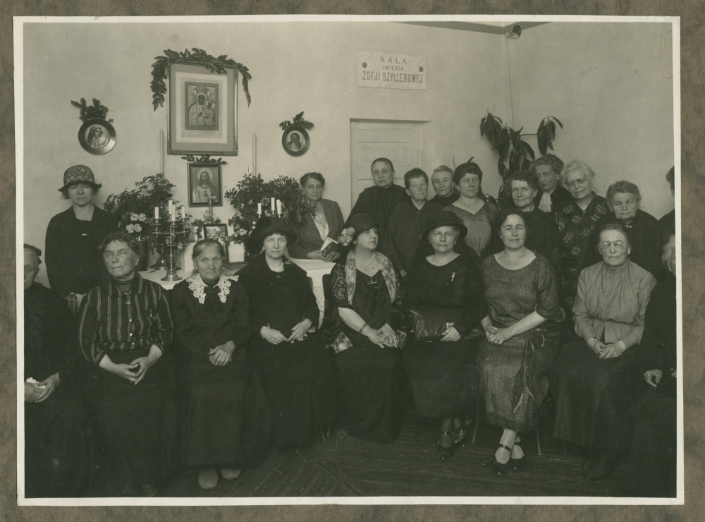 Photographie d'Hélène Paderewski entourée de Mme Rembielinska (à sa gauche), de sa secrétaire Hélène Lübke (tout à gauche) et, sans doute, d'autres bénévoles de la Croix Blanche polonaise, assemblées en une «Salle Zofia Sziller»
