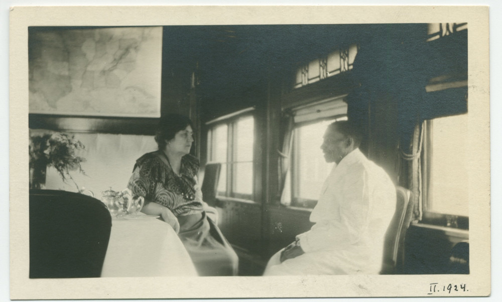 Photographie d'Hélène Paderewska attablée dans le pullman-car privé de ses tournées américaines en compagnie du fidèle cuisinier noir John, en gare Tucson, Arizona, le 25 février 1924