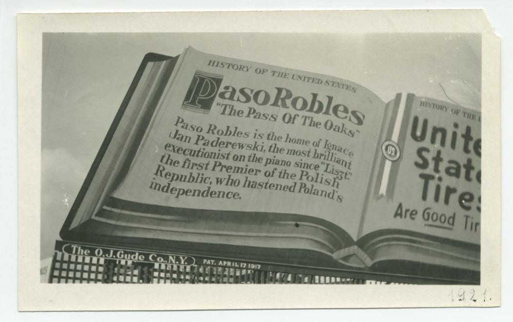 Photographie d'un panneau publicitaire à la gloire des «United States Tires» [«Les bons pneus américains»] et de Paso Robles, en Californie, «The Pass Of The Oaks» [«Le col des chênes»] et «home of Ignace Jan Paderewski…»