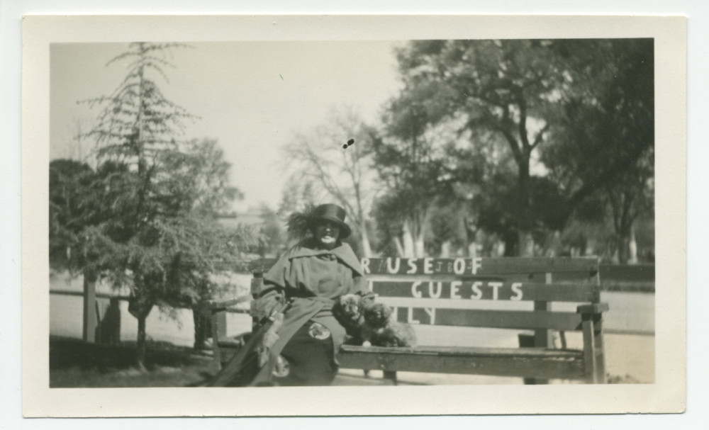 Photographie d'Hélène Paderewska et de son chien Ping sur un banc devant l'hôtel de Paso Robles, en Californie, le 4 mars 1924