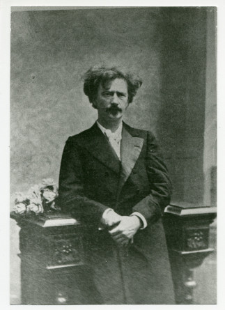 Photographie de Paderewski debout, de face, accoudé à un meuble, prise à Varsovie en 1908