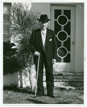 Photographie de Paderewski debout avec chapeau noir et canne dans le jardin de sa résidence de Palm Beach, en Floride, le 19 février 1941