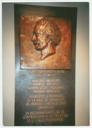 Photographie de la plaque commémorative posée le 28 novembre 1997 à la salle Paderewski à Lausanne «en reconnaissance de [la] contribution [de Paderewski] à [sa] création», couronnée par un relief en bronze réalisé par l'artiste vaudoise Colette Jotterand