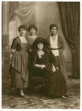 Photographie d'Hélène Paderewska, avec chapeau noir et collier de perles, assise entourée de trois jeunes femmes dont sa secrétaire Mlle Hélène Lübke (debout au milieu), réalisée probablement le 5 février 1920