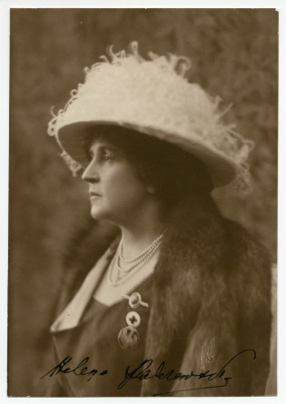 Photographie de profil d'Hélène Paderewska en 1923, avec chapeau blanc, collier de perles, insignes de la Croix Blanche polonaise et de l'aigle polonais, et signature originale