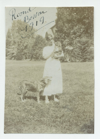Photographie d'une jeune femme en 1919 dans le parc de Riond-Bosson, en compagnie de deux chiens