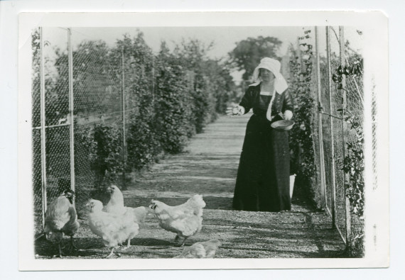 Photographie d'Hélène Paderewska nourrissant ses poules primées dans le jardin de Riond-Bosson