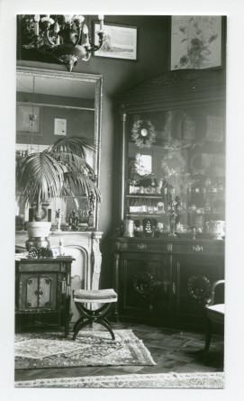 Photographie de détail du cabinet des trophées du salon de Riond-Bosson, avec cheminée et vitrine