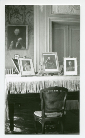 Photographie d'un piano à queue du salon de Riond-Bosson, avec exposées dessus des photos dédicacées de la reine Elisabeth de Belgique, de la reine Victoria et du roi Albert de Belgique
