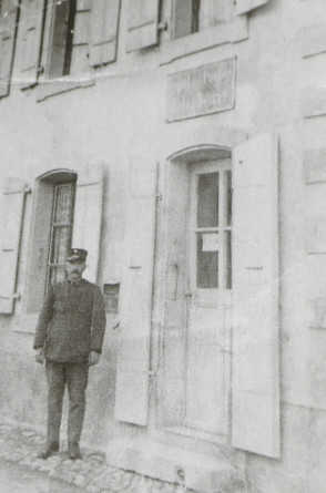 Photographie du buraliste postal de Tolochenaz, Emile Panchaud, devant le bureau de poste du 17 de la rue du Centre, en 1900