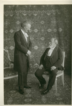 Photographie de Camille Saint-Saëns (assis) et Paderewski (debout) face-à-face, réalisée dans les salons de l'Hôtel des Trois Couronnes à Vevey dans le cadre des Fêtes musicales données du 18 au 21 mai 1913 en l'honneur de Camille Saint-Saëns