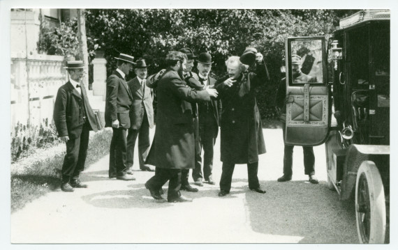 Photographie de Paderewski montant dans sa voiture devant le Casino du Rivage à Vevey, en saluant le chef d'orchestre Ernest Ansermet (de profil), le compositeur Gustave Doret, le syndic de Vevey Eugène Couvreu (avec le chapeau melon) et Samuel Gétaz (?)
