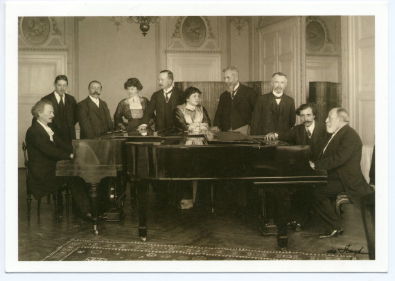 Carte postale représentant Paderewski et Camille Saint-Saëns face-à-face au piano dans les salons de l'Hôtel des Trois Couronnes à Vevey dans le cadre des Fêtes musicales données du 18 au 21 mai 1913 en l'honneur de Camille Saint-Saëns