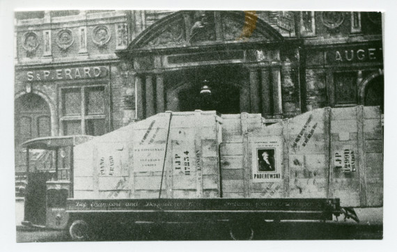 Photographie d'un camion avec sur son pont 2 pianos à queue dans des caisses (dont l'une portant une affiche de Paderewski placardée sur son flanc) en partance pour l'Angleterre, devant la maison Erard à Paris
