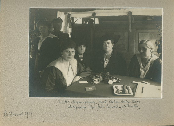 Photographie du réfectoire de la Croix Blanche polonaise (occupé sans doute par des bénévoles) installé dans un wagon à destination de la 1re Division (d'infanterie?) polonaise sur le front lituanien, en octobre (probablement 1920 plutôt que 1919)