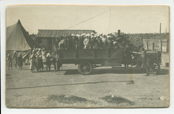 Photographie d'enfants «candidats à l'émigration» sur le pont d'un camion, prêts au départ d'une crèche de la Fondation éducative Hélène Paderewska, probablement en 1922 – avec légende manuscrite et tampons au verso