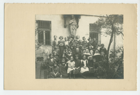 Photographie d'une classe de filles de cinquième année (sans doute financée par la Croix Blanche polonaise) avec enseignants (religieux) – avec signatures de toutes les élèves et tampon du photographe au verso