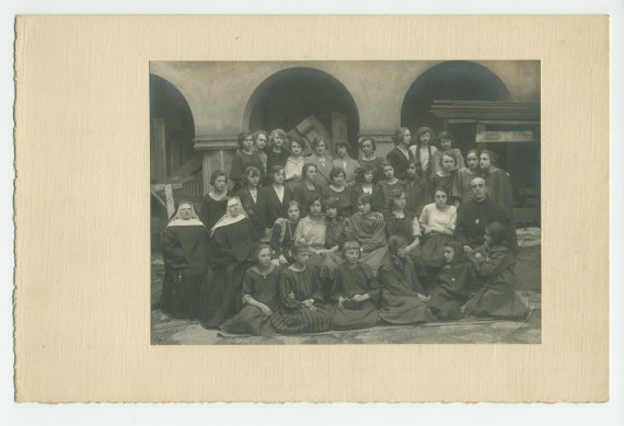 Photographie d'une classe de filles de huitième année (sans doute financée par la Croix Blanche polonaise) avec enseignants (religieux) – avec signatures de toutes les élèves et tampon du photographe au verso