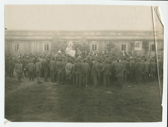 Photographie (de presse) de la «bénédiction de la maison pour les prisonniers de guerre par la Croix Blanche polonaise à Deblin», ville de la voïvodie de Lublin, dans l'est de la Pologne – avec légende manuscrite et tampon «service de presse» au verso