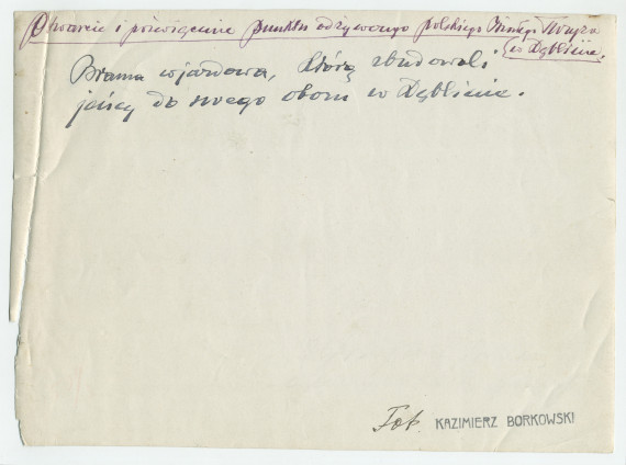 Photographie du panneau de bienvenue réalisé par des prisonniers de guerre au point d'alimentation de la Croix Blanche polonaise à Deblin, ville de la voïvodie de Lublin, dans l'est de la Pologne – avec légende manuscrite et nom du photographe au verso