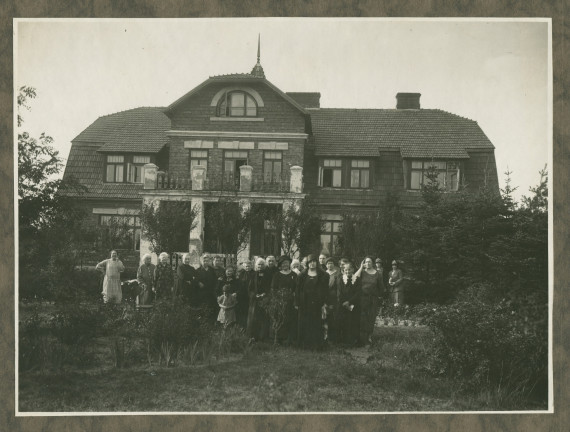 Photographie d'Hélène Paderewska devant une maison en compagnie sans doute de femmes bénévoles de la Croix Blanche polonaise