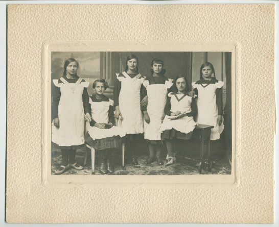 Photographie de six jeunes filles en uniforme portant leurs «remerciements à Madame et Bienfaitrice pour qu'elle accepte le dons de nos filles» – avec légende manuscrite et signatures des six filles au verso