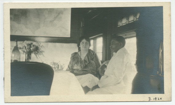 Photographie d'Hélène Paderewska attablée dans le pullman-car privé de ses tournées américaines en compagnie du fidèle cuisinier noir John, en gare Tucson, Arizona, le 25 février 1924