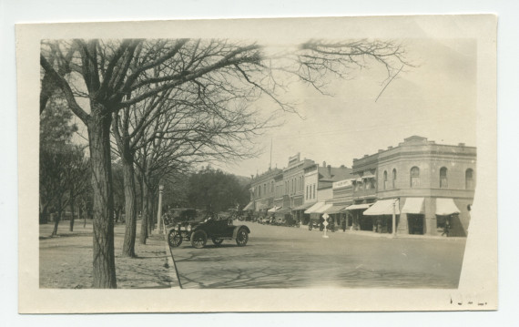 Photographie de la rue centrale de Paso Robles, en Californie, avec ses voitures parquées et son parc, en 1922