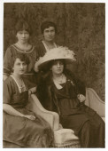Photographie d'Hélène Paderewska en 1923, avec chapeau blanc et collier de perles, assise entourée de trois jeunes femmes dont sa secrétaire Mlle Hélène Lübke (debout à gauche)