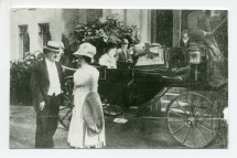 Photographie d'Hélène et Ignace Paderewski devant l'entrée principale de Riond-Bosson, avec derrière eux un landau conduisant trois dames