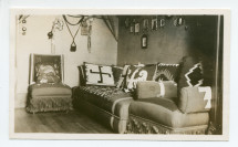 Photographie d'un coin de la bibliothèque du 3e étage de Riond-Bosson, avec canapé, fauteuils et des coussins aux motifs polonais