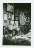 Photographie d'un coin du cabinet des trophées du salon de Riond-Bosson, avec un fauteuil